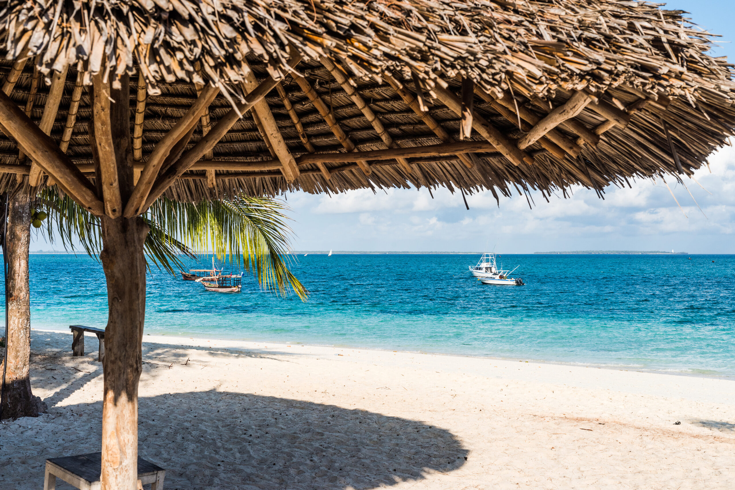 beautiful colorful view of blue ocean from beach with straw umbrella