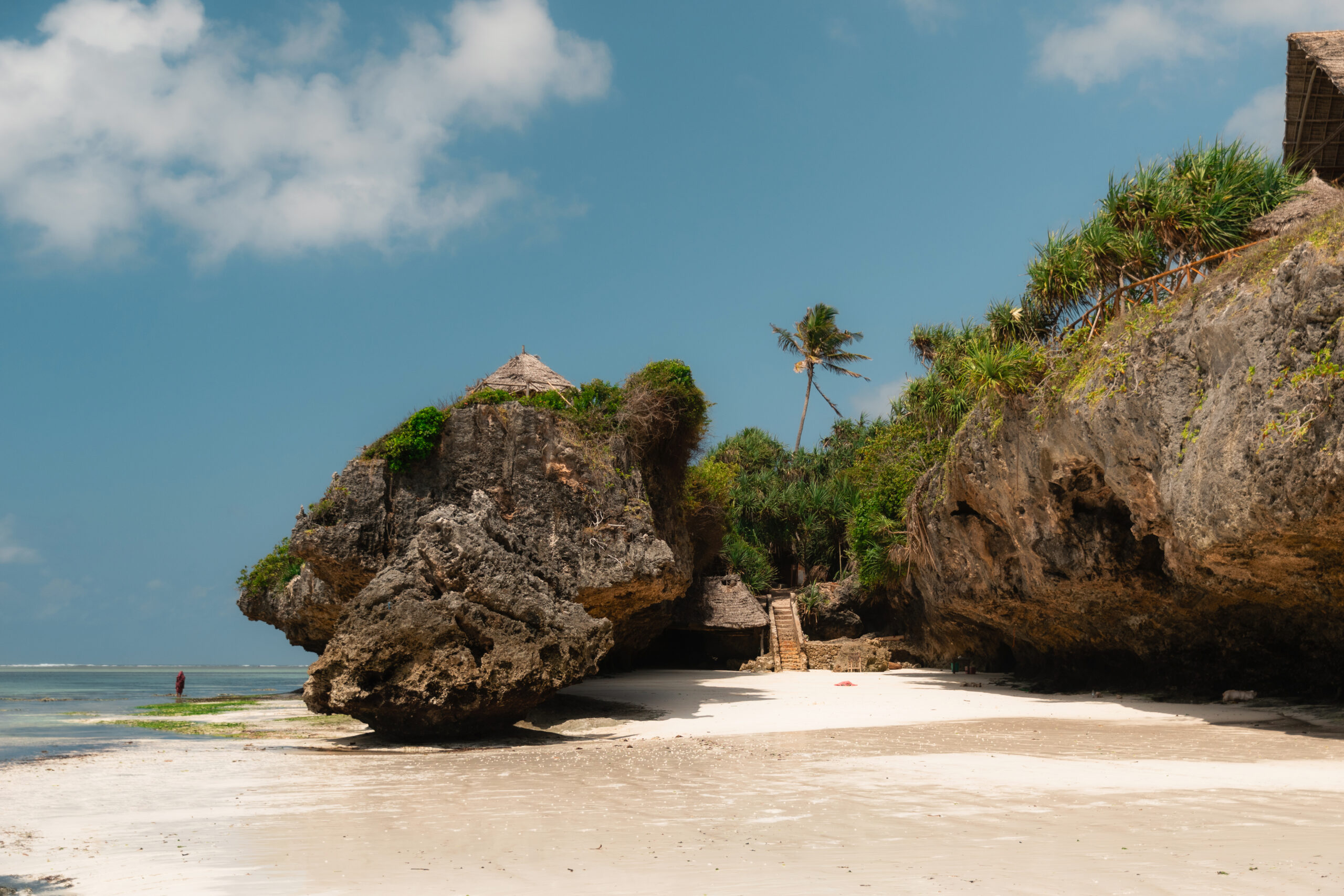 Breathtaking view of a pristine white sand beach nestled amongst dramatic rock formations in zanzibar, tanzania, creating a secluded tropical paradise